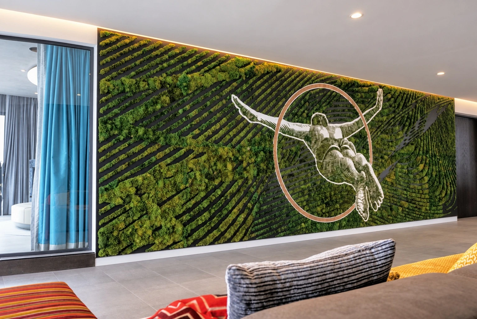 Otra vista de la instalación mural de musgo con una figura